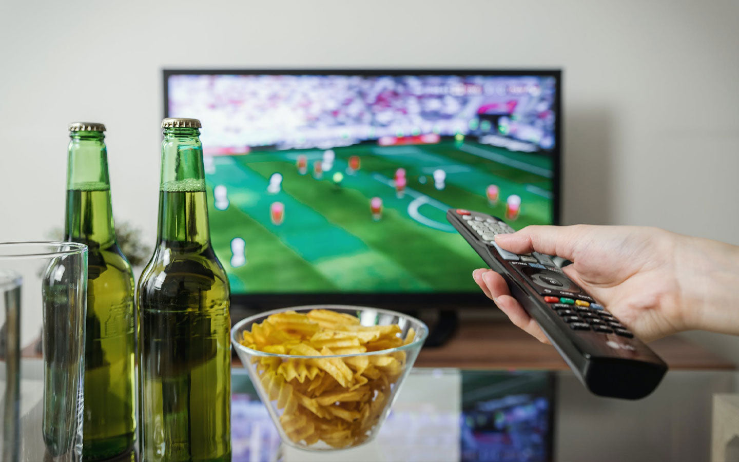friends gathered around the tv watching a sports event