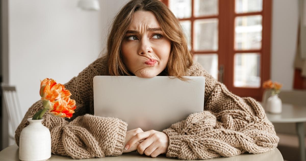 Woman sitting at computer wondering if she's hungry or thirsty