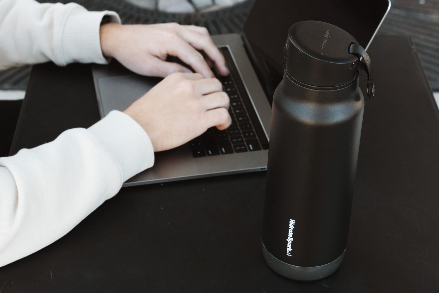 A HidrateSpark smart water bottle glowing to remind you to drink.